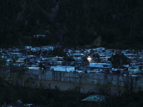 A car passes among dark homes as people wait for electricity to be restored after Hurricane Maria passed through in Utuado, Puerto Rico.JOE RAEDLE/GETTY IMAGES