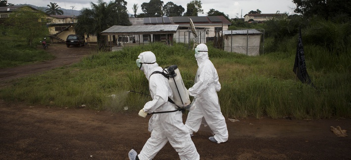 Healthcare workers in Sierra Leone spray disinfectant to prevent the spread of the Ebola virus in Kenema, on September 24, 2014.
