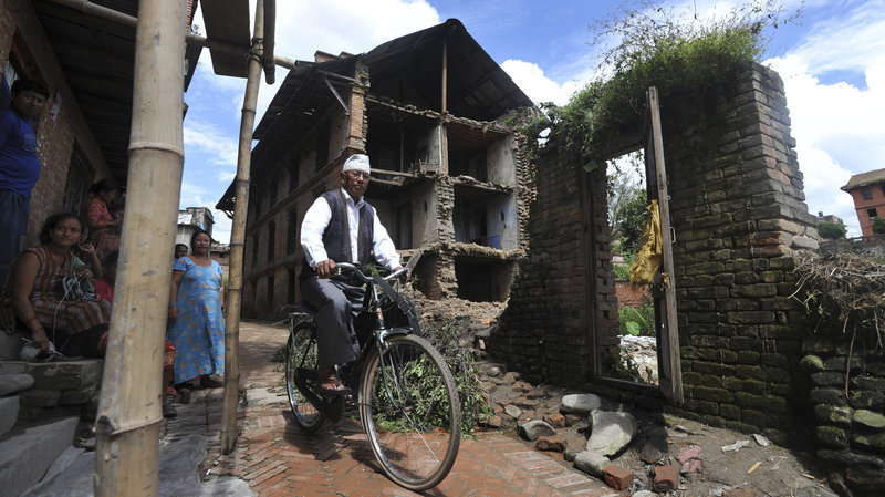 A bicyclist passes a home damaged in a 2011 earthquake at Bhaktapur, some 7 miles southeast of Kathmandu. Prakash Mathema /AFP/Getty Images