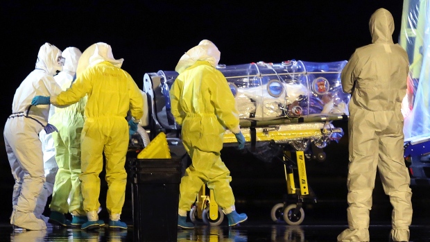Aid workers and doctors transfer Manuel Garcia Viejo, a Spanish priest who was diagnosed with the Ebola virus while working in Sierra Leone, from a military plane to an ambulance, near Madrid on Monday. (Spanish Defence Ministry/Associated Press) 